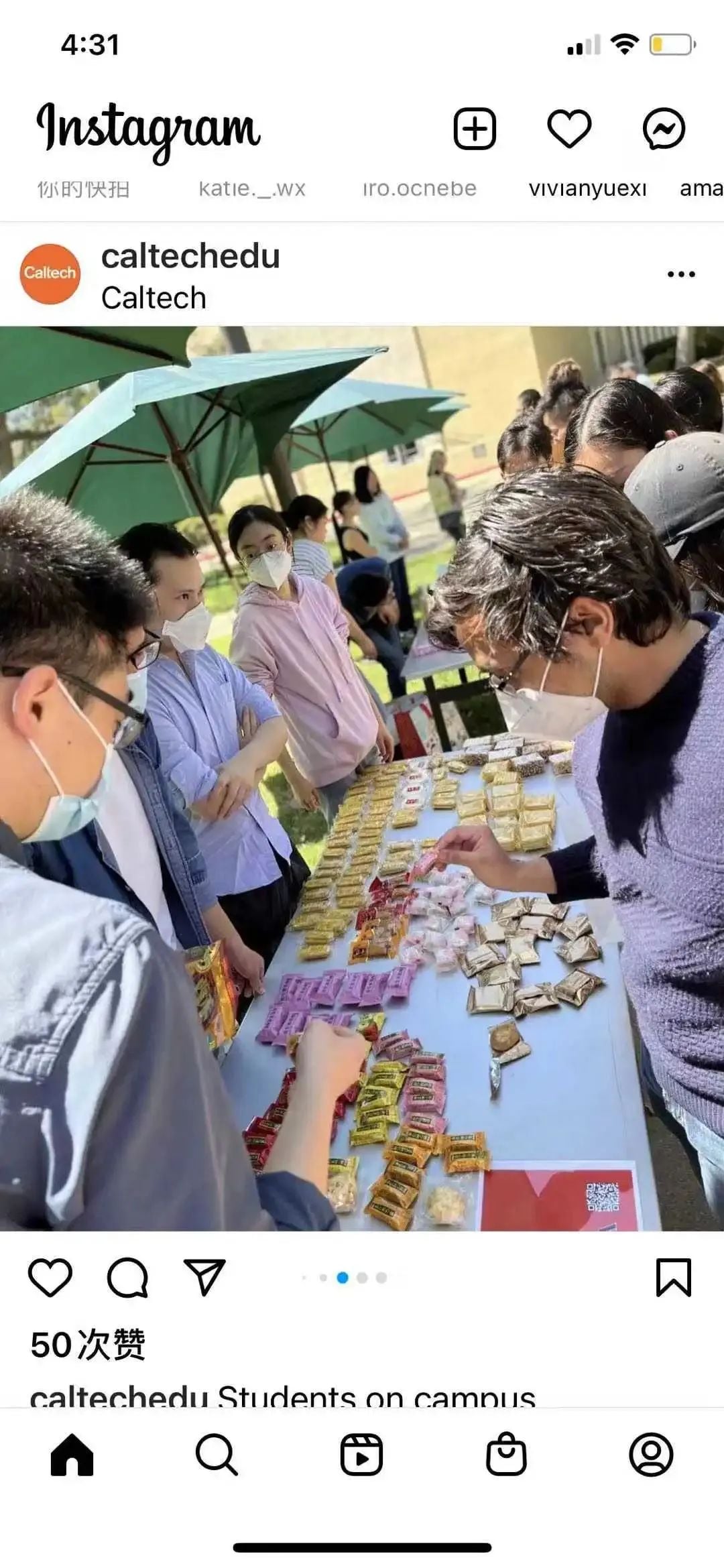 Instagram screenshot: Students gather around an outdoor table laden with packaged snacks under green umbrellas. Some wear masks.